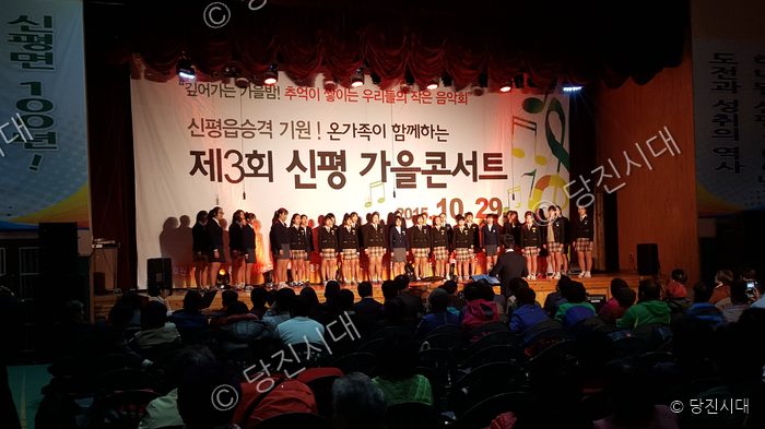 합창단이 무대 위에서 가을 음악회를 열고 있다.