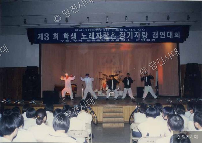 학생들이 무대에서 노래와 장기자랑 경연대회를 하고 있다.