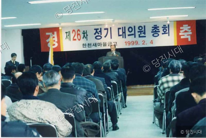 한천새마을금고 제26차 정기 대의원 총회에서 사람들이 회의를 듣고 있다.