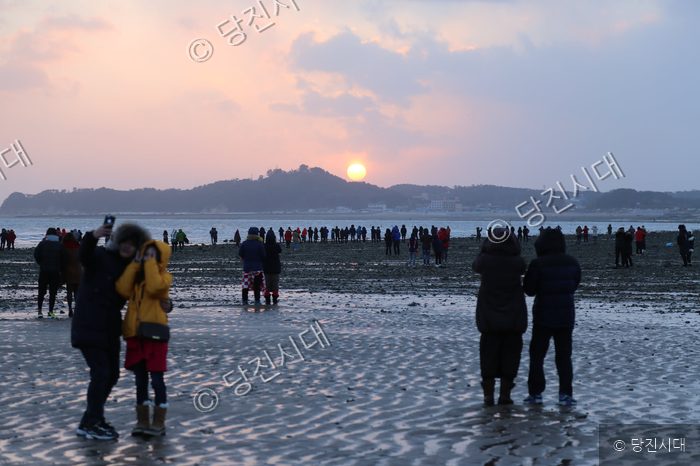 왜목마을 해맞이 축제에서 사람들이 새해 일출을 감상하고 있다.