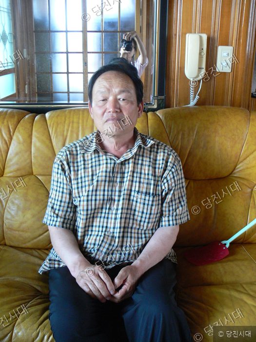 김진만 씨가 실내 소파에 앉아 카메라를 바라보고 있다.