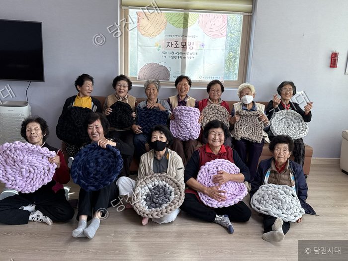 정경윤 관장 등이 직접 만든 뜨개질 공예품을 들고 환하게 웃고 있다.