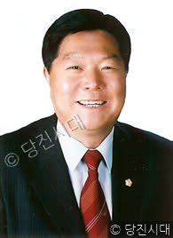 김천환 후보가 정장 차림으로 밝게 미소 지으며 카메라를 응시하고 있다.