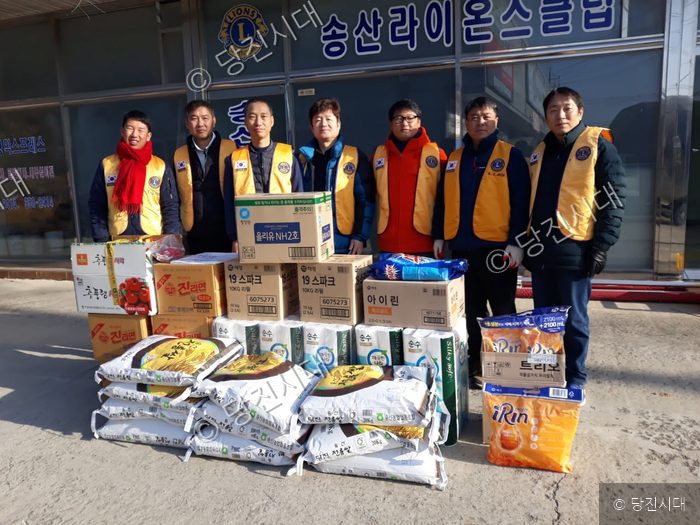 송산라이온스클럽 회원들이 물품을 기부하고 기념촬영을 하고 있다.