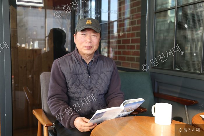 김종범 씨가 카페에 앉아 책을 읽고 있다.