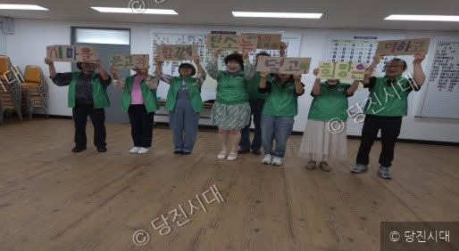 새마을문고 회원들이 구호를 적은 피켓을 들고 기념 촬영을 하고 있다.