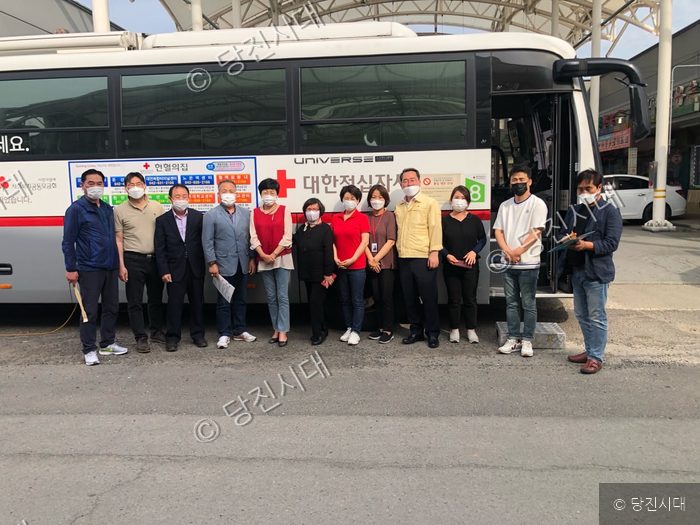 합덕읍주민자치회 관계자들이 코로나19 극복 헌혈캠페인 버스 앞에서 기념촬영을 하고 있다.