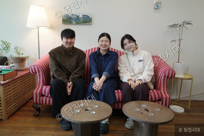 합덕제작소를 운영하는 대표들이 소파에 나란히 앉아 미소 짓고 있다.