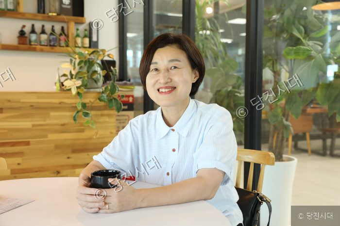 김진숙 진보당 당진시위원회 위원장이 카페에 앉아 미소를 짓고 있다.