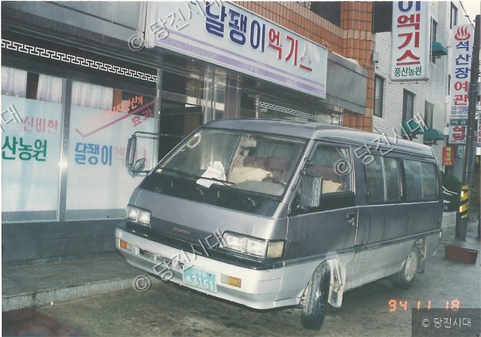 어느 상점 앞에 주차된 승합차가 보이고 있다.