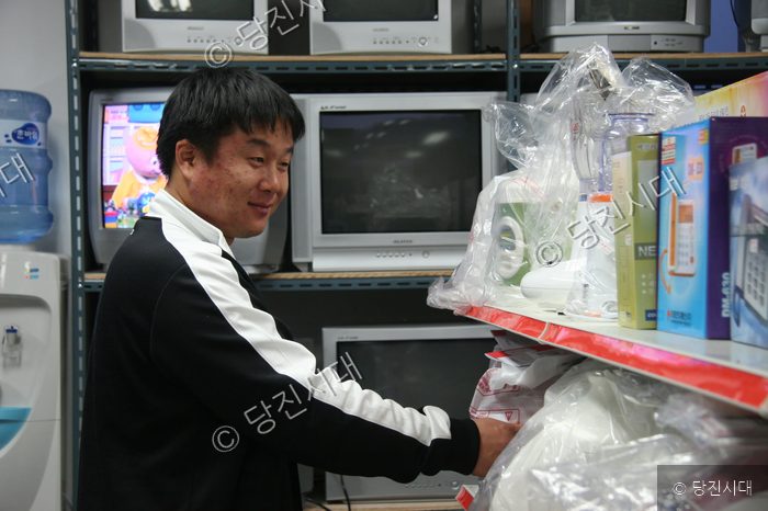 신바람 씨가 상가 매장 안에서 가전제품을 살펴보고 있다.