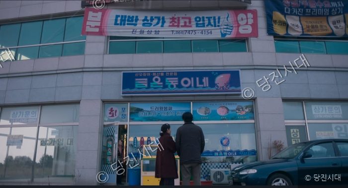 두 사람이 식당 건물 앞에 서서 바라보고 있다.