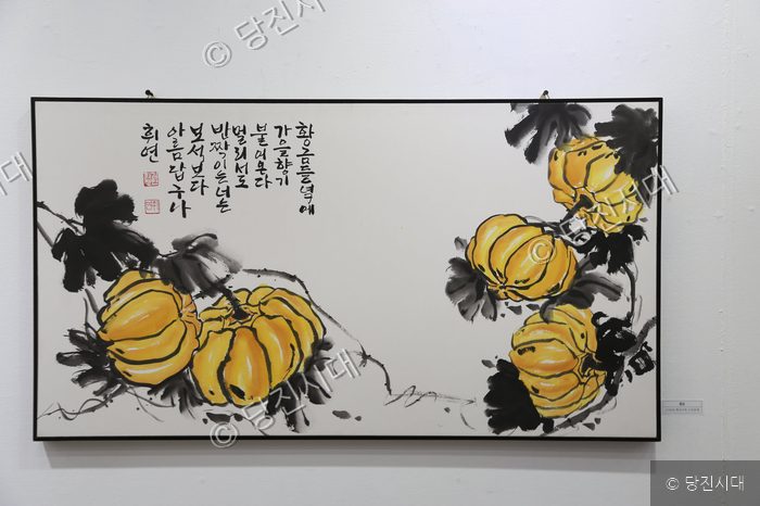 김희정 작가의 노란 호박과 시가 적힌 한국화 작품