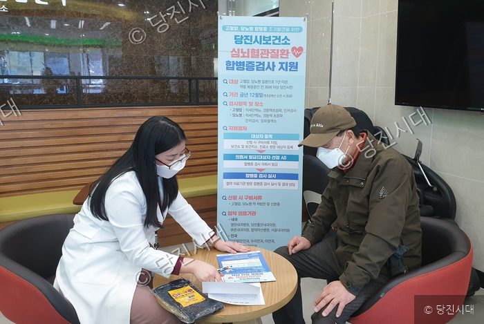 당진시보건소 직원이 시민에게 심뇌혈관질환 합병증 검사를 안내하고 있다.
