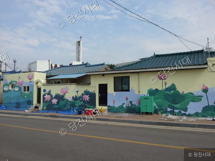 마을 담장에 연꽃 벽화가 그려져 있다.