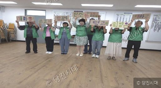 새마을운동당진시지회 회원들이 피켓을 들고 기념 촬영을 하고 있다.