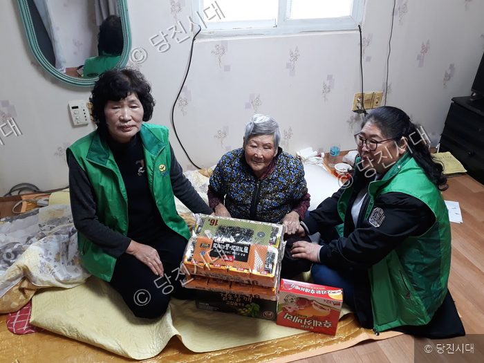봉사자들이 어르신을 찾아가 선물을 전달하고 있다.
