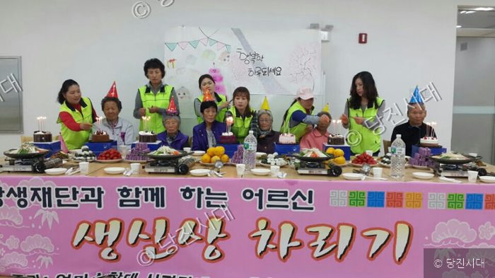 자원봉사자들이 어르신들과 함께 생신상 차리기 행사를 하고 있다.