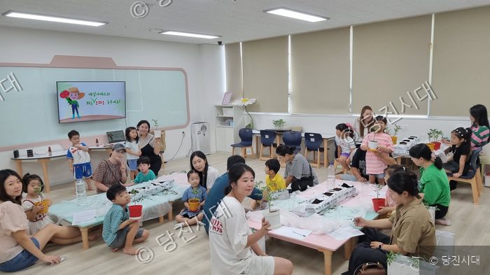 당진시가족센터에서 어린이와 학부모들이 토마토 생태교육과 모종심기 체험을 하고 있다.
