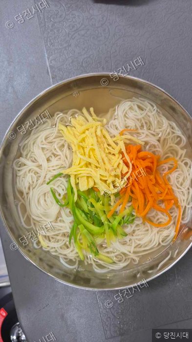 식당에서 준비된 멸치국수 한 그릇이 그릇에 담겨 있다.