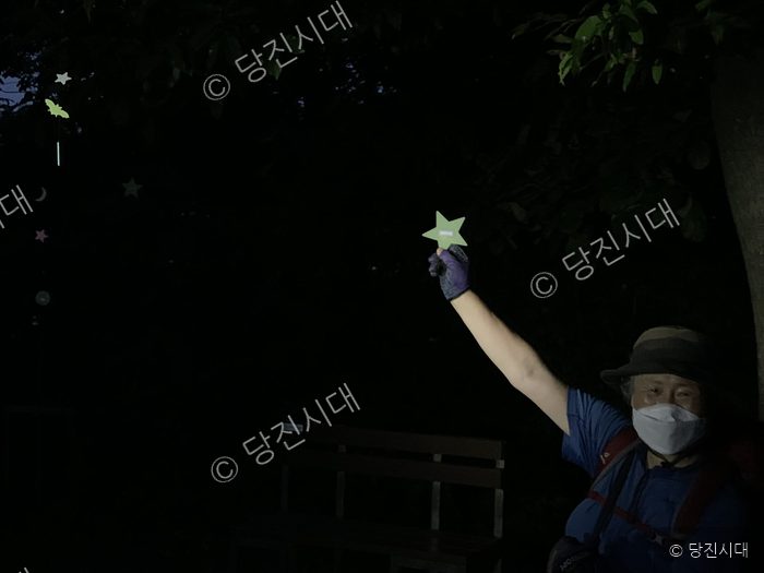 야간에 아미산 숲길을 찾은 시민이 별 모양 장식을 들고 있다.