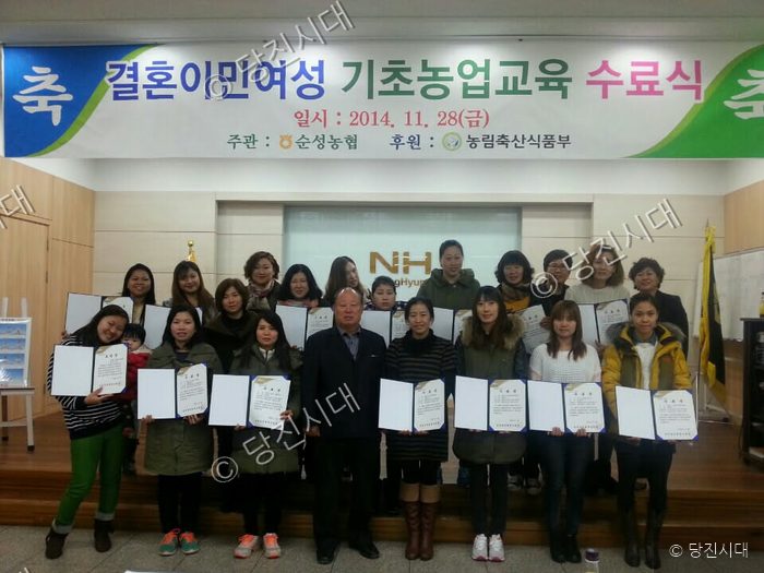 결혼이민여성들이 기초농업교육 수료식에서 수료증을 들고 기념 촬영을 하고 있다.