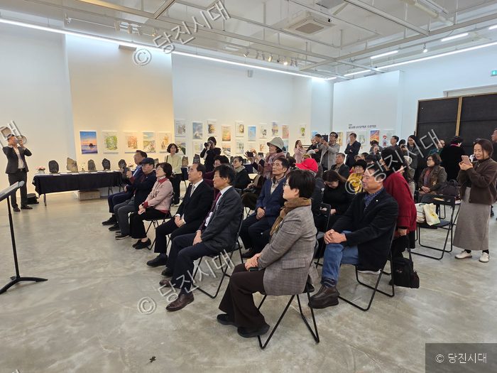 김명수 작가 등이 당진문학제 행사에 참석해 전시를 관람하고 있다.