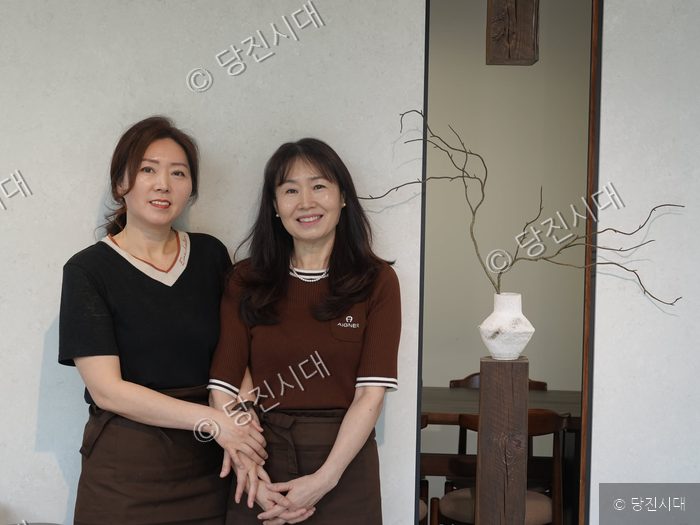 커피브라운 조은실·조은미 대표가 나란히 서서 미소 짓고 있다.