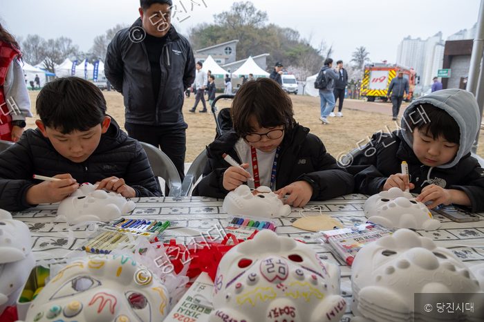 어린이들이 축제 부스에서 가면 만들기 체험을 하고 있다.