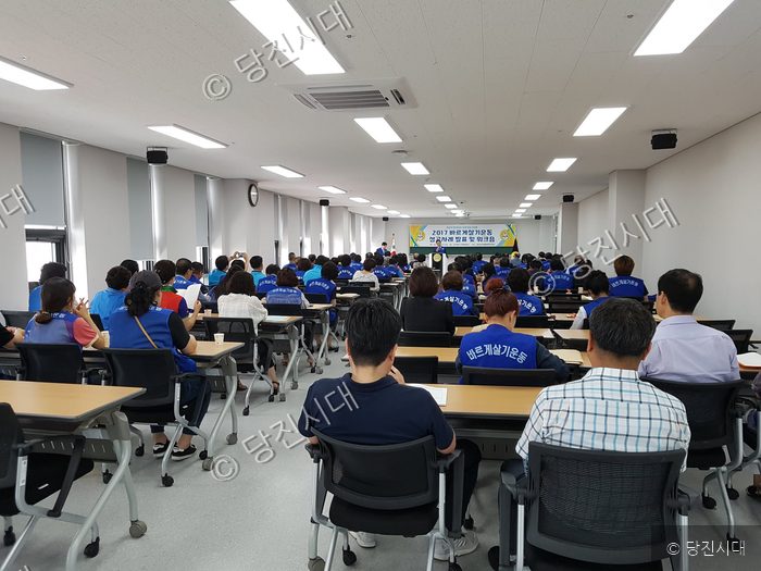 사람들이 강당에서 바르게살기운동 워크숍에 참석하고 있다.