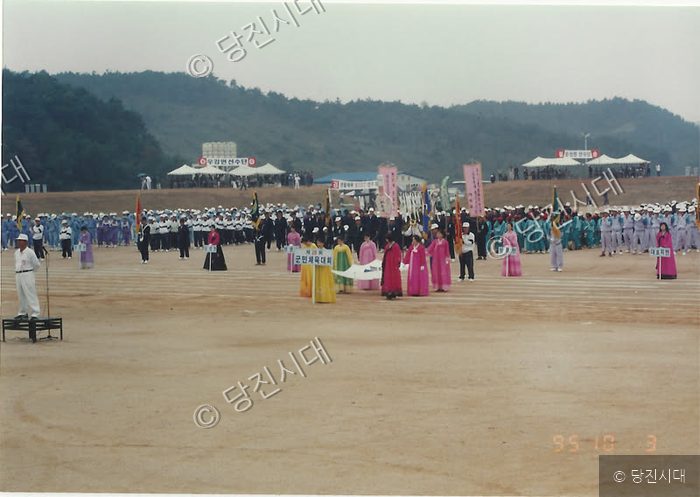 운동장에서 주민들과 선수단이 모여 체육대회를 개최하고 있다.