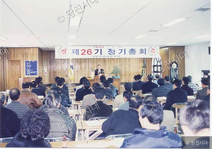 실내 강연장에서 사람들이 제26기 정기총회에 참석하고 있다.
