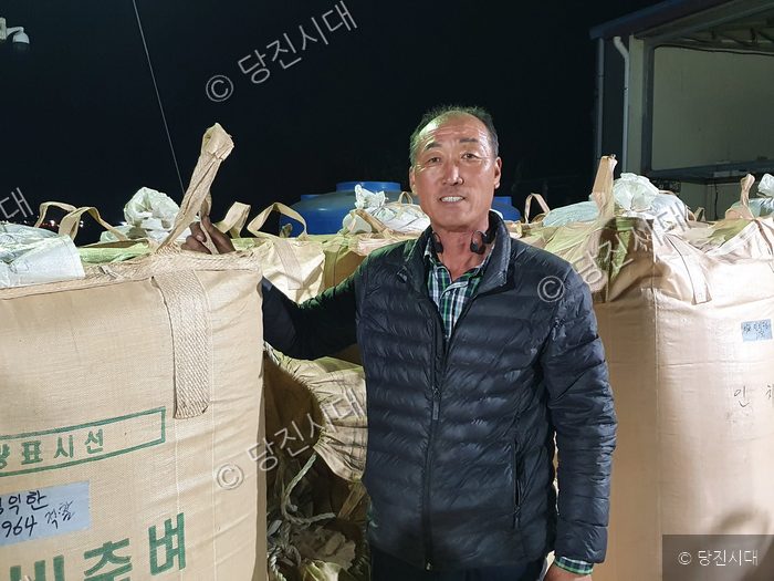 김익한 대표가 대형 쌀 포대 앞에서 포즈를 취하고 있다.