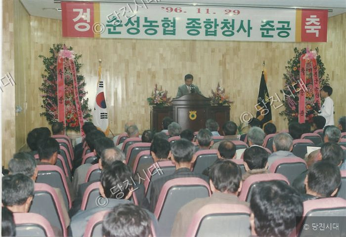 사람들이 실내에서 농협 종합청사 준공식 행사에 참석해 있다.