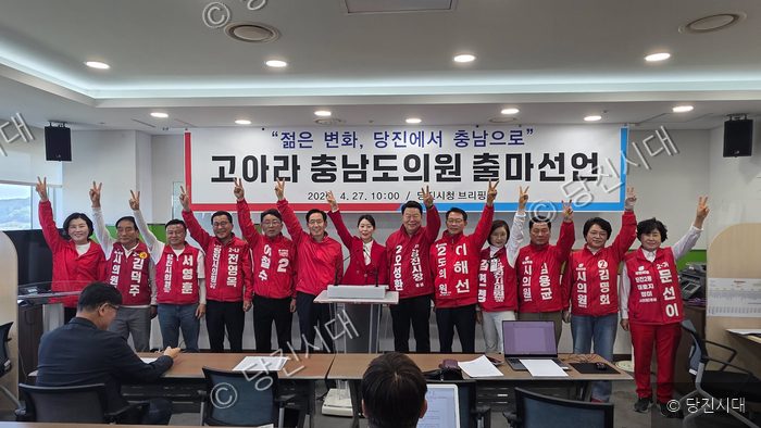 출마 선언 회견에서 후보와 지지자들이 기념 촬영을 하고 있다.