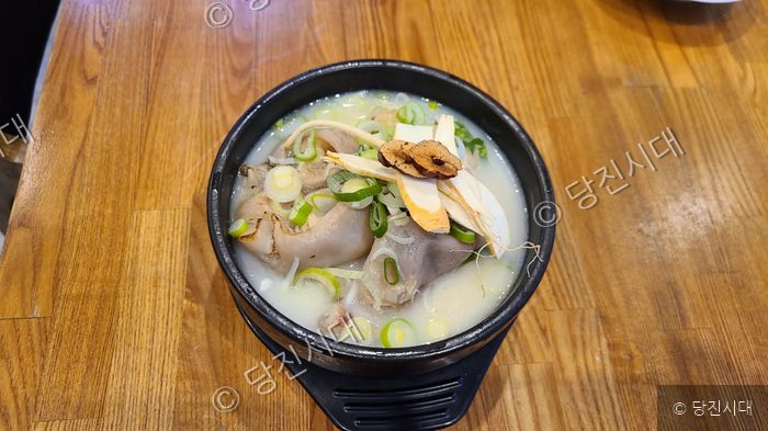 식당 테이블 위에 한방 족발탕이 놓여 있다.