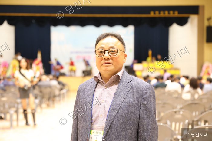 송악중학교 실내 체육관에서 열린 총동문회에서 김동섭 회장이 카메라를 바라보고 있다.