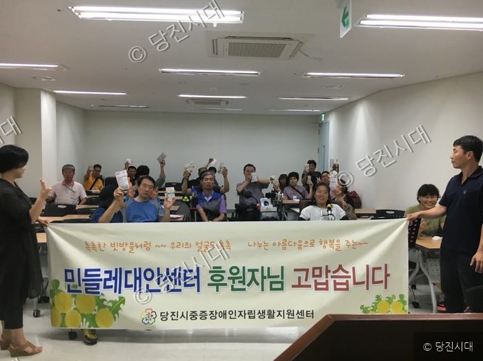 민들레대안센터에서 후원받은 마스크팩을 들고 기념 촬영을 하고 있다.