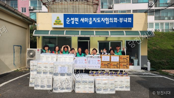순성면 새마을지도자협의회·부녀회 회원들이 후원 물품을 전달하며 기념 촬영을 하고 있다.