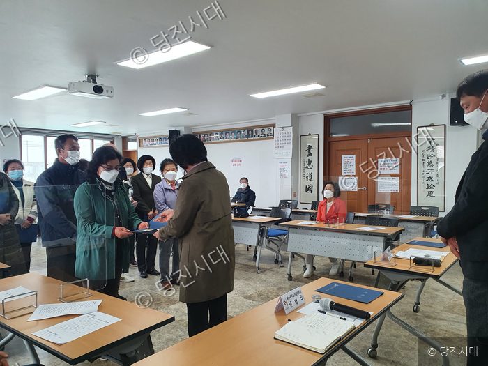 사람들이 회의실에서 문서를 주고받으며 모임을 하고 있다.