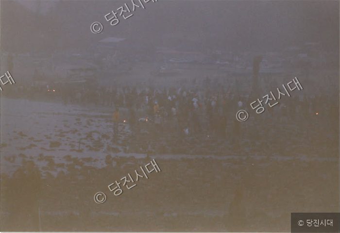 최평곤 씨 등이 해변에서 설치 작업 현장을 바라보고 있다.