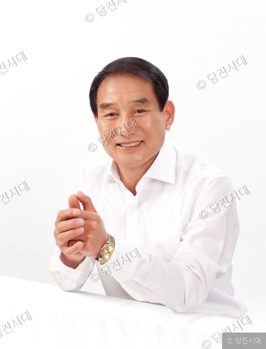 국민의힘 김덕주 예비후보가 흰 셔츠 차림으로 미소 짓고 있다.