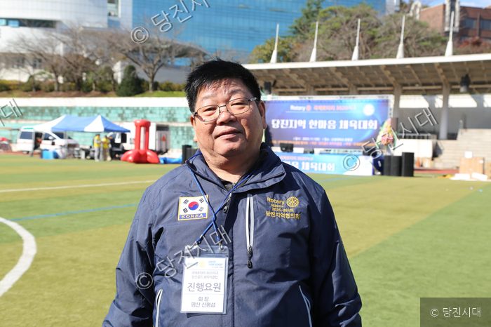로타리클럽 신형섭 회장이 행사장 야외에서 포즈를 취하고 있다.