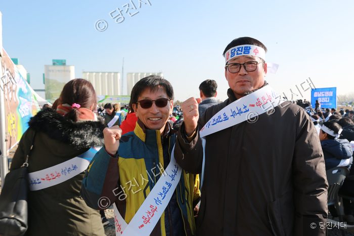 두 남성이 주먹을 쥐고 구호를 외치고 있다.