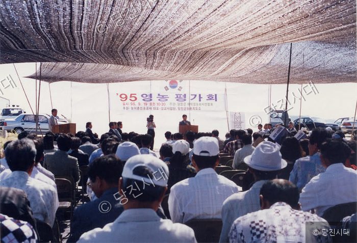 야외 천막 아래에서 1995년 영농 평가회가 열리고 있다.