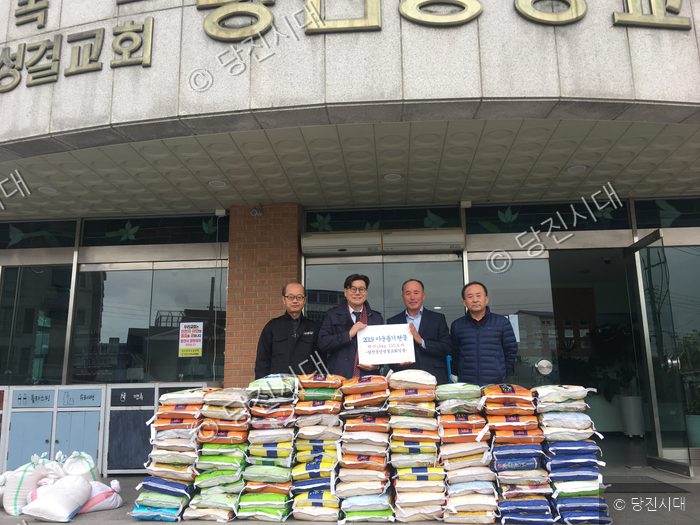 당진중앙성결교회 관계자들이 이웃돕기 백미를 전달하며 기념 촬영을 하고 있다.
