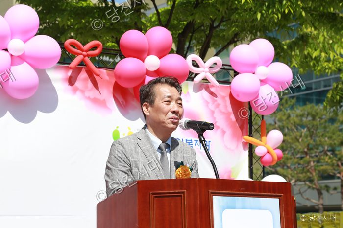 최태선 씨가 노인복지관 카네이션 대축제에서 마이크를 잡고 발언하고 있다.