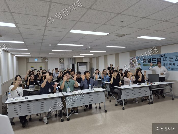 참석자들이 당진 정원드림프로젝트 발대식에서 손을 들어 기념촬영을 하고 있다.