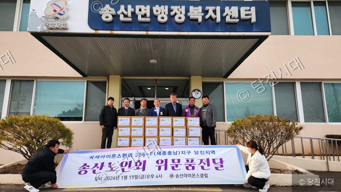 송산라이온스클럽이 경로당에 위문품을 전달하고 기념 촬영을 하고 있다.