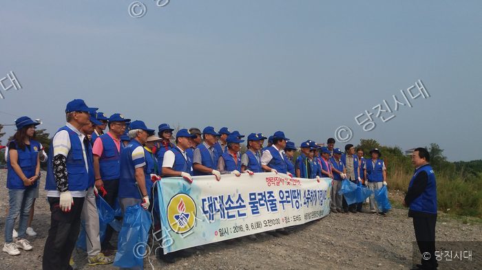 바르게살기운동 회원들이 도비도에서 환경정화 활동을 하고 있다.